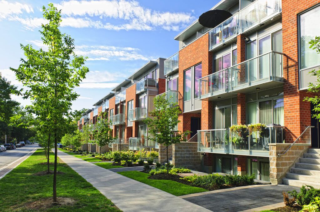 Photo of modern brick townhomes, with manicured patios and boulevards.